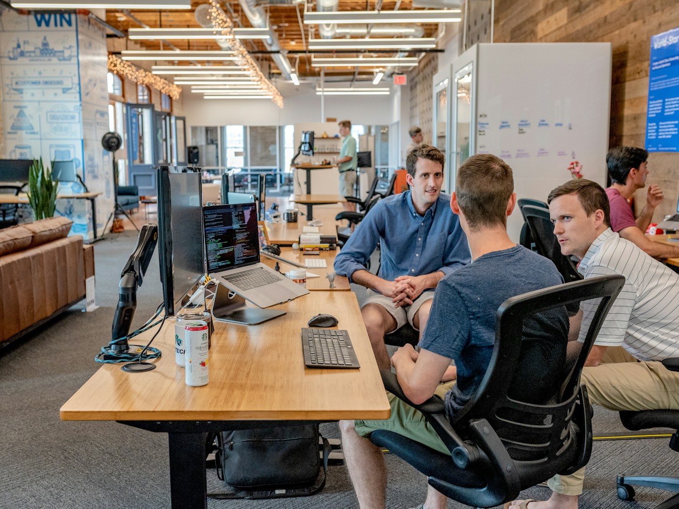 Three colleagues discussing work in a shared office